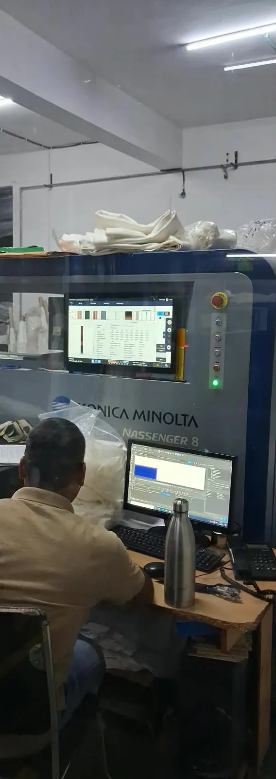 Operator preparing a print job in RIP software beside Fabloom's Konica Minolta Nassenger 8 digital textile printer